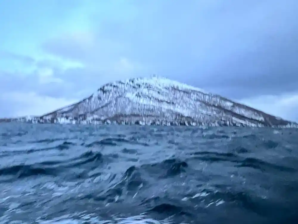 Dark swell running below a white ridge under a blue winter sky