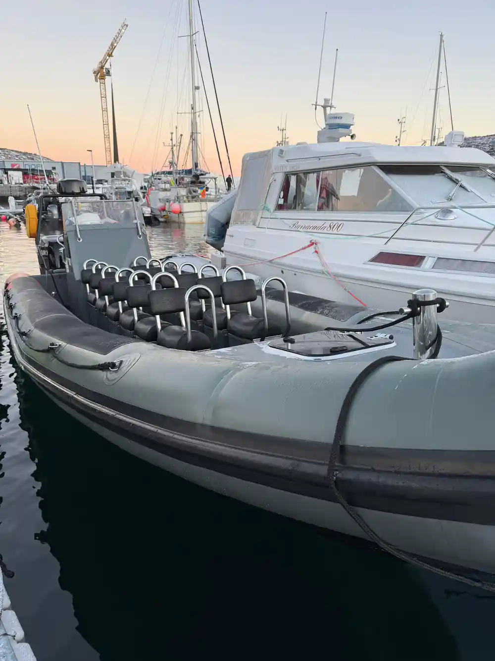 The empty RIB at the dock showing rows of straddle seats and handholds