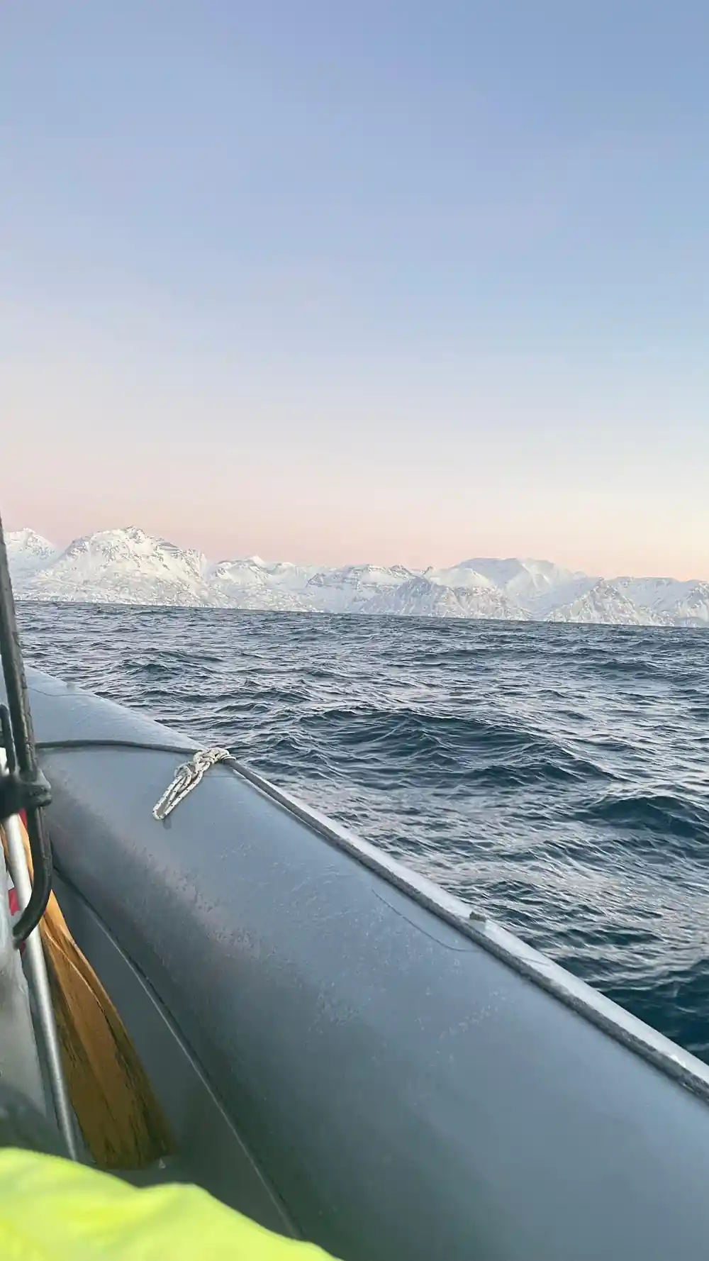 The grey tube and bow of the RIB running through open water